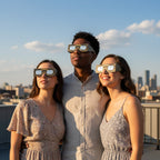 A group of friends wearing Astral design glasses, enjoying a rooftop gathering and looking up at the sky for August 12, 2026.
