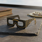 Showcasing Astral design solar eclipse glasses on a dark slate slab, perfect for safe viewing on August 12, 2026.