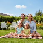 Family of four in a backyard wearing Colorsplash glasses, enjoying a bright day together while looking up.