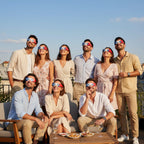 Group of friends at a rooftop party in Paris, all wearing FR solar eclipse glasses, looking up in amazement.