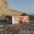 Elegant solar eclipse glasses on a weathered stone ledge, perfect for safe viewing. ISO 12312-2 certified.