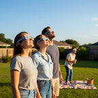Friends in a backyard gathering, wearing Memphis design eclipse glasses, captivated by the sky, ISO 12312-2 compliant.