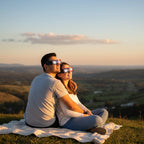 A young couple wearing Nebula design eclipse glasses on a grassy hilltop, sharing awe under the sky, CE certified.
