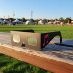 Vibrant still life of Notes design eclipse glasses on a sunlit wooden surface, ideal for safe viewing of the August 12, 2026 eclipse.
