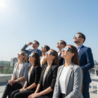 A diverse group of eight professionals at a rooftop terrace, all wearing eclipse glasses and looking skyward in wonder. 2026-eclipse.