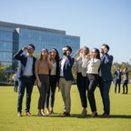 Diverse colleagues wearing Rocketrider glasses during a corporate event, looking up at the midday sky together. 12 Aug 2026.
