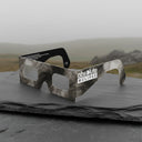 A professional showcase of Soot design eclipse glasses on a textured slate slab, perfect for safe viewing.