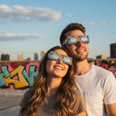 A couple on a sunlit urban rooftop joyfully wearing eclipse glasses, sharing a special moment together. CE certified.
