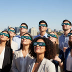 Eight young professionals on a rooftop event, all wearing Voltage glasses, looking up with wonder, enjoying a safe experience.