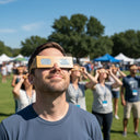 Adults at a community festival, wearing Wood design glasses and sharing an experience of wonder under a sunny sky.